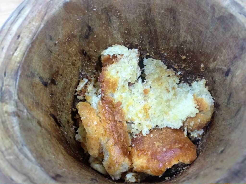 caldereta de cordero extremeña, majando el pan con el ajo